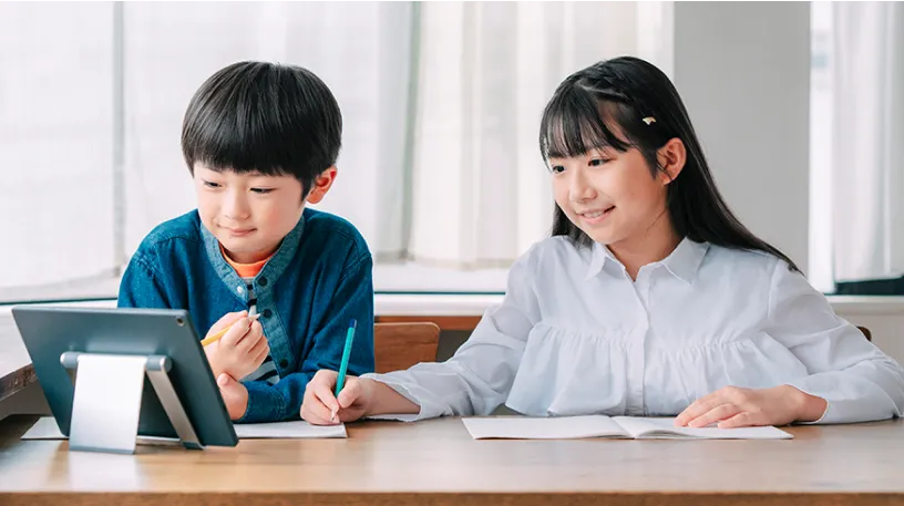 男の子と女の子がタブレットを見ている写真